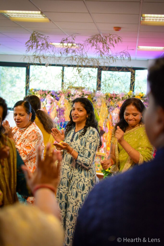 Women singing and clapping together during the Janmashtami celebration at Dharma Mandir Newport.