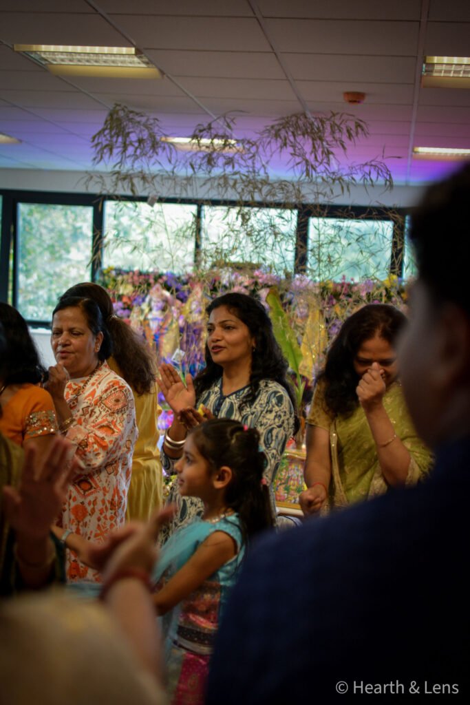 Women and a child taking part in singing and celebrations at Dharma Mandir Newport.