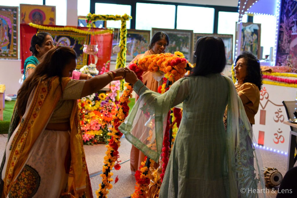 Women holding hands and dancing together during the Janmashtami celebration at Dharma Mandir Newport.
