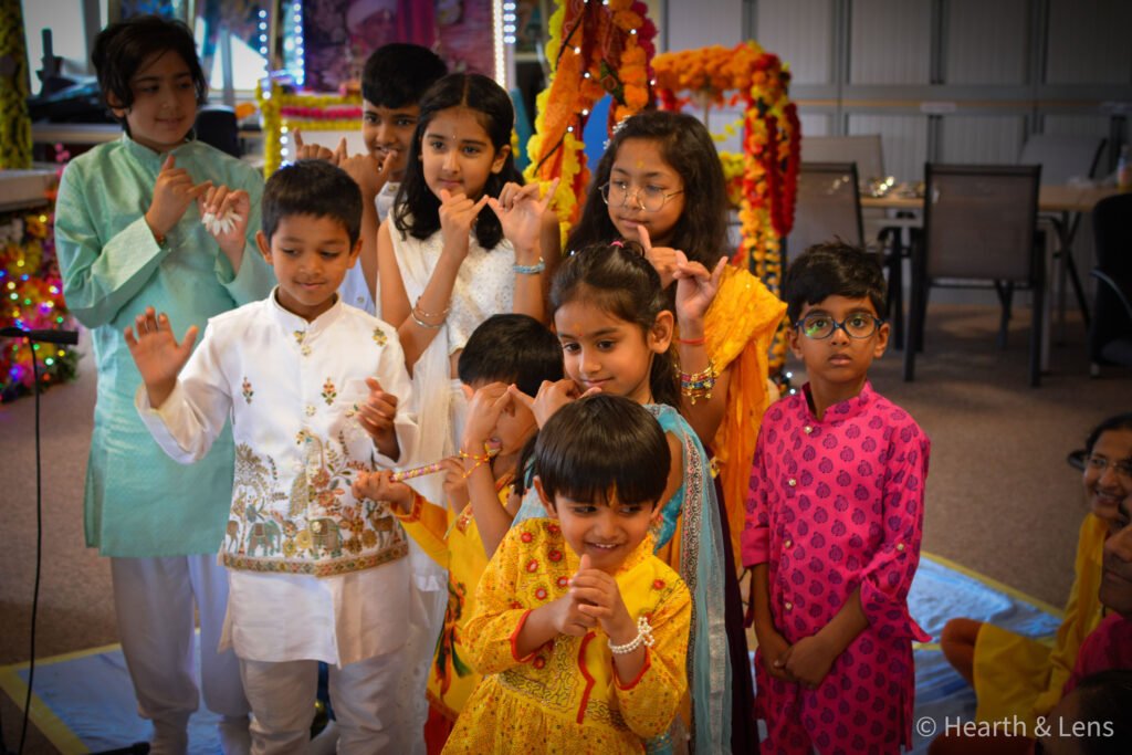 Children smiling and making playful gestures during the Janmashtami celebration at Dharma Mandir Newport.