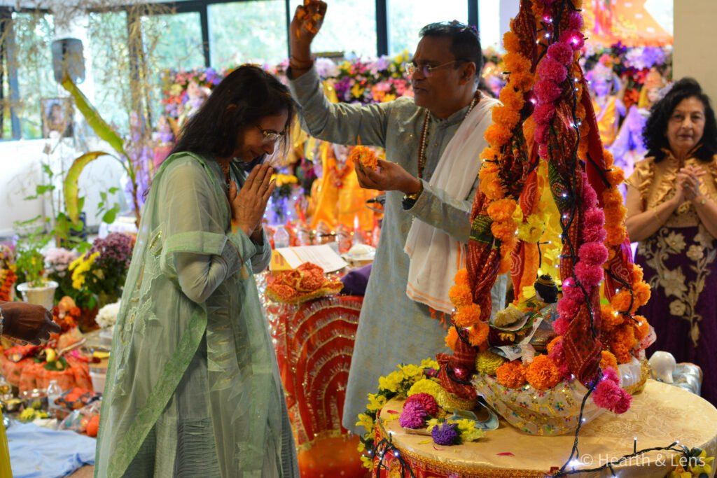 A devotee receiving blessings during pooja at the Janmashtami celebration at Dharma Mandir Newport.