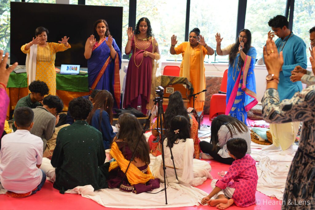 Children seated together as elders recite prayers and offer blessings at Dharma Mandir Newport.
