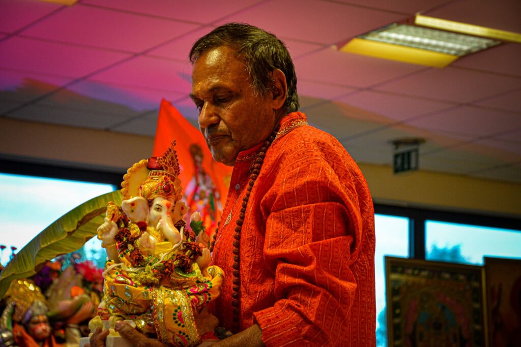 Devotees performing rituals to welcome Ganapati at Dharma Mandir in Newport