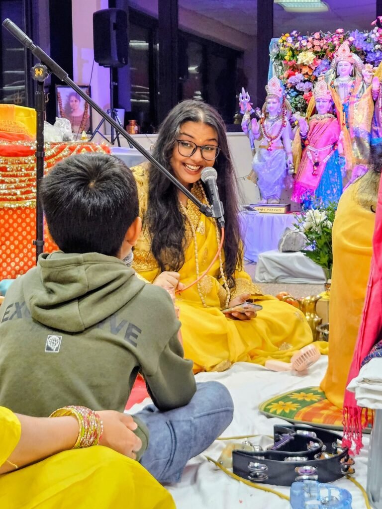 Sri Goberdhan guiding the ceremony on the microphone while engaging with a young participant